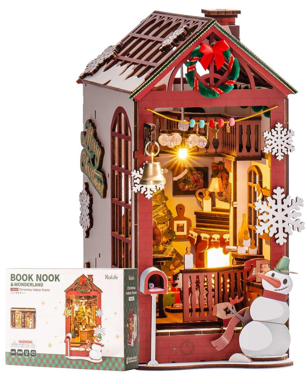 Wooden dollhouse with lights and decorations, including a snowman and wreath, on a white background.