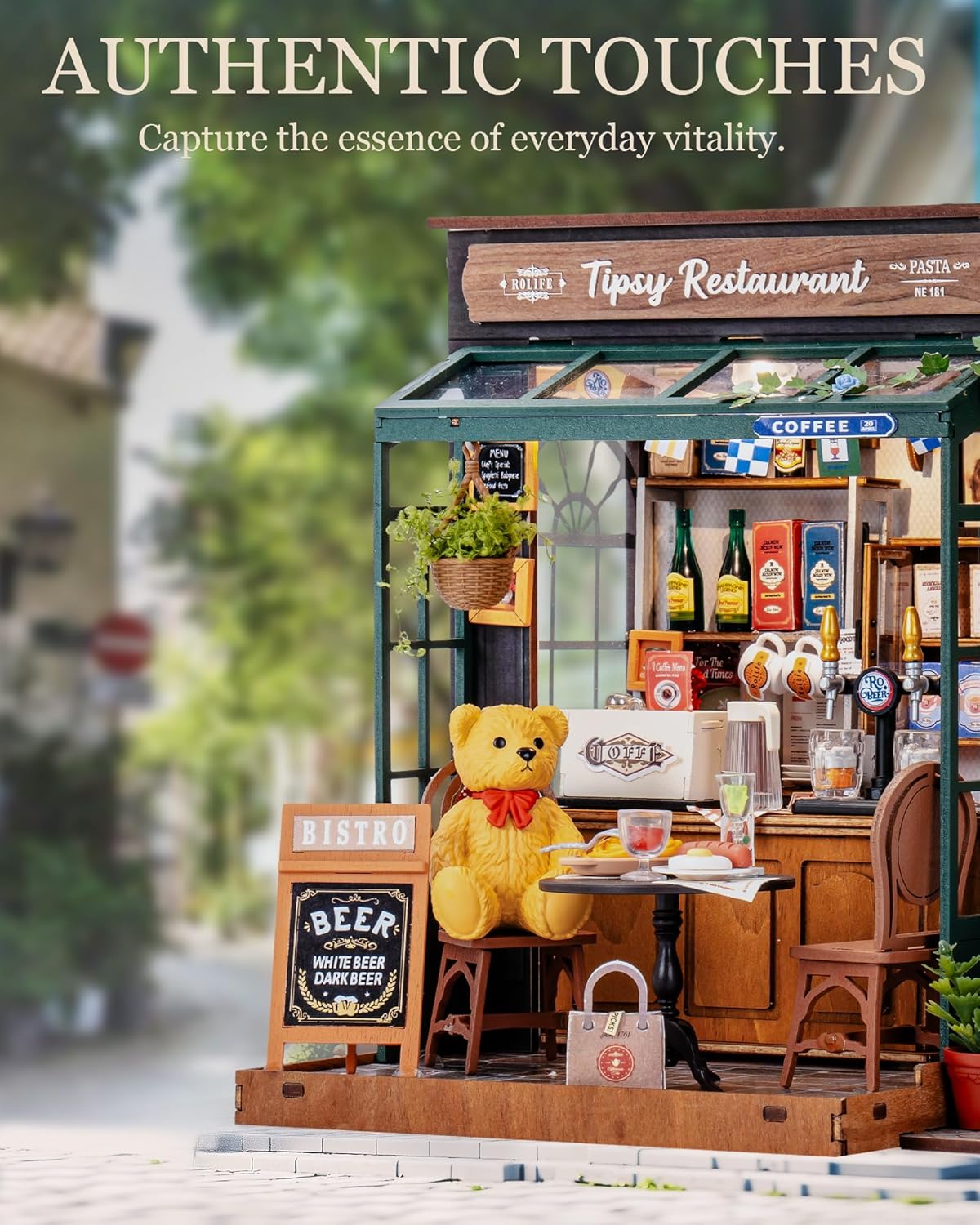 Model of a restaurant with a teddy bear sitting at a table, surrounded by various items and a blurred outdoor background.