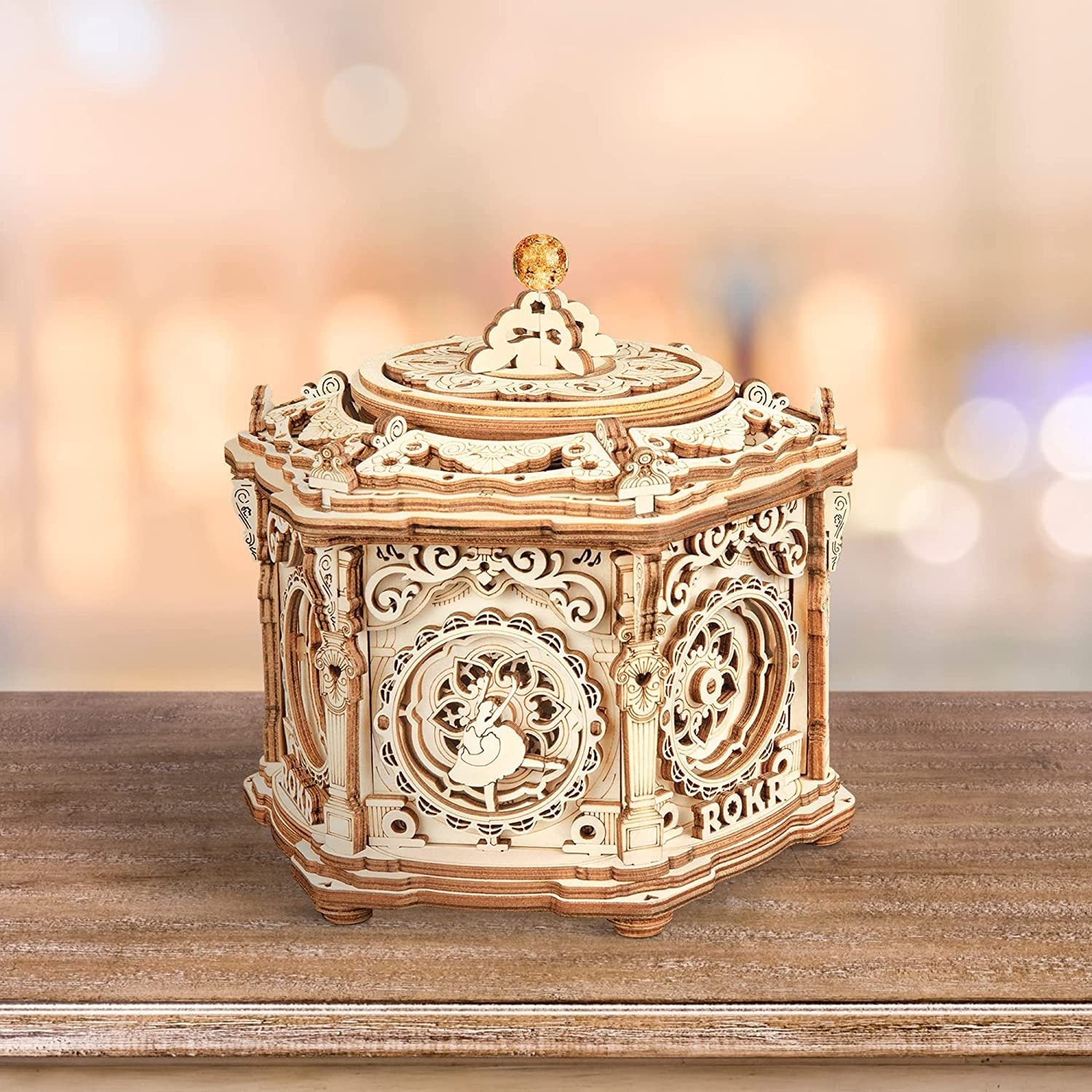 Wooden mechanical model with intricate designs on a wooden surface